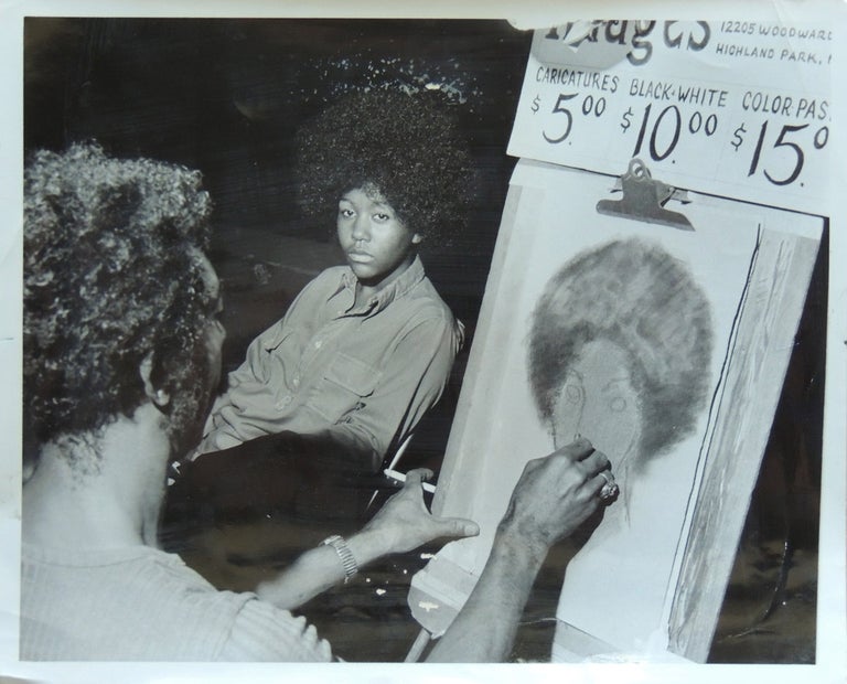 Item #422 July 23-24, 1972 Press Photograph of a teenage African-American girl sitting for an African-American artist sketching her during a festival in Highland Park, MI (metro Detroit area).